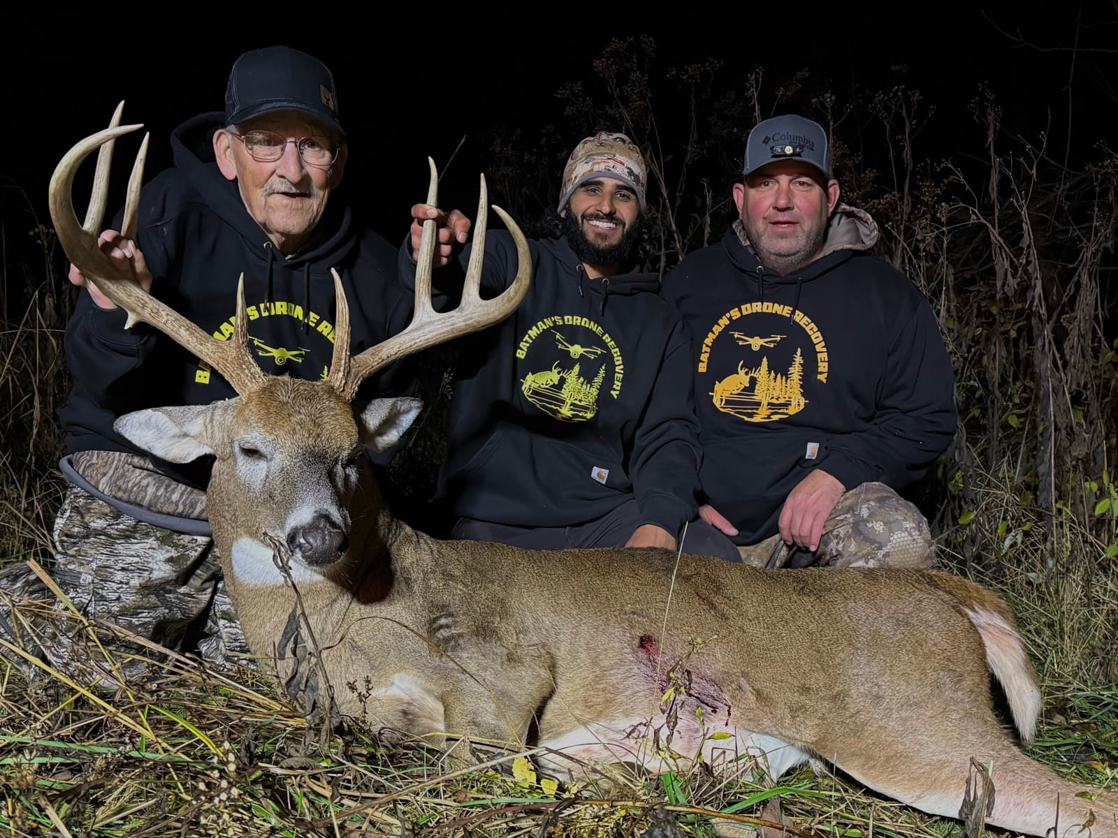 Three generations of hunters with a recovered buck on a night recovery