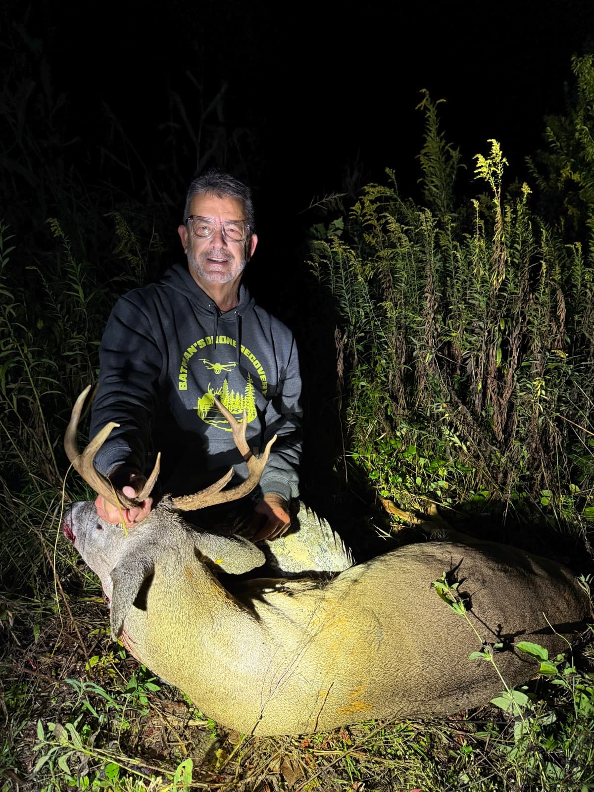 Hunter with a heavy-antlered buck recovered on a night search